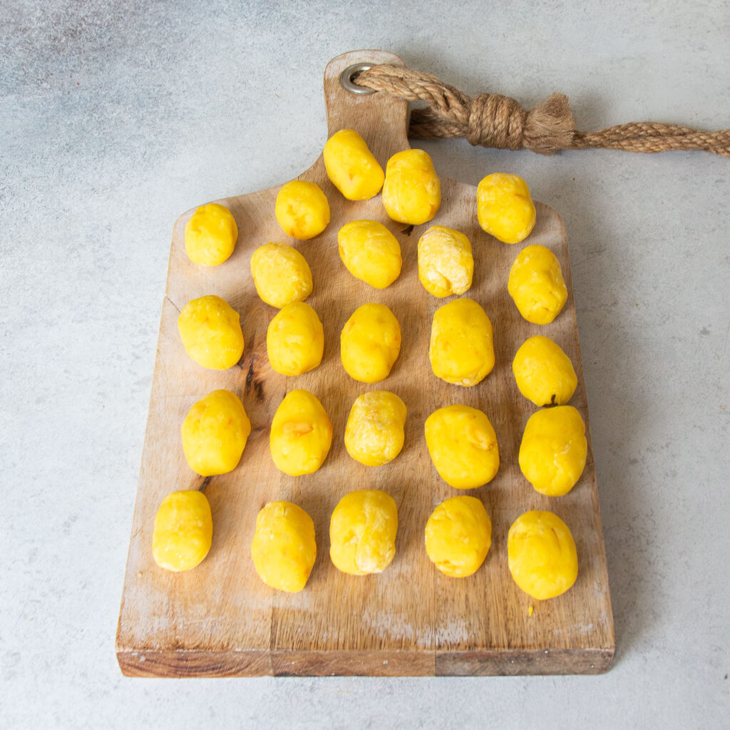 Ungekochte Kürbis-Gnocchi auf einem Brett.