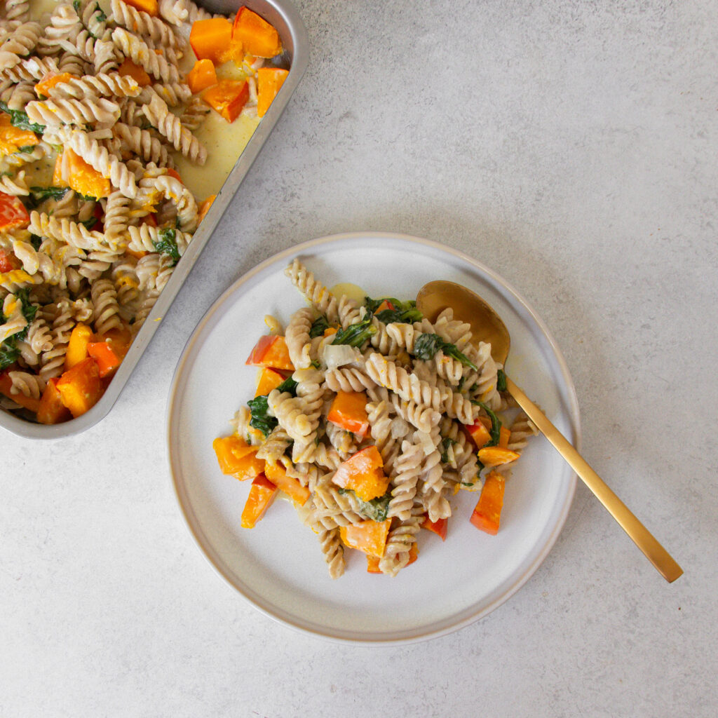 Teller gefüllt mit Ein Blech Kürbis-Pasta und Löffel