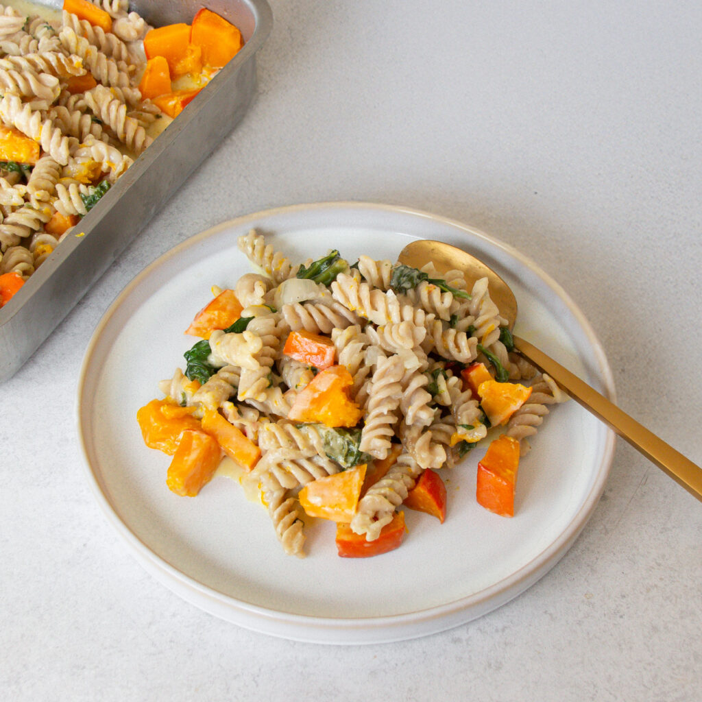 Teller gefüllt mit Ein Blech Kürbis-Pasta und Löffel