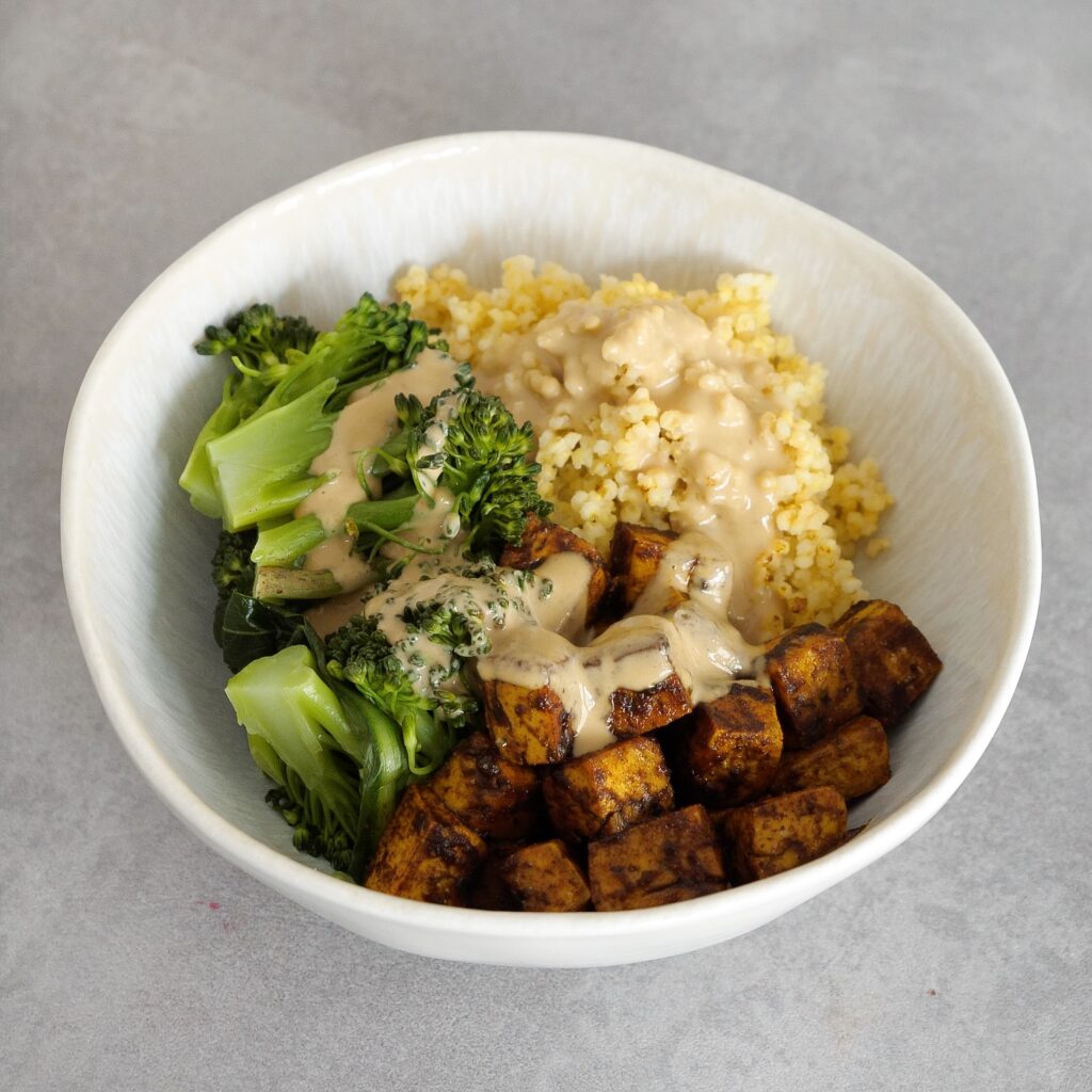Hirse-Tofu-Bowl mit Tahini-Soße in einer Schüssel