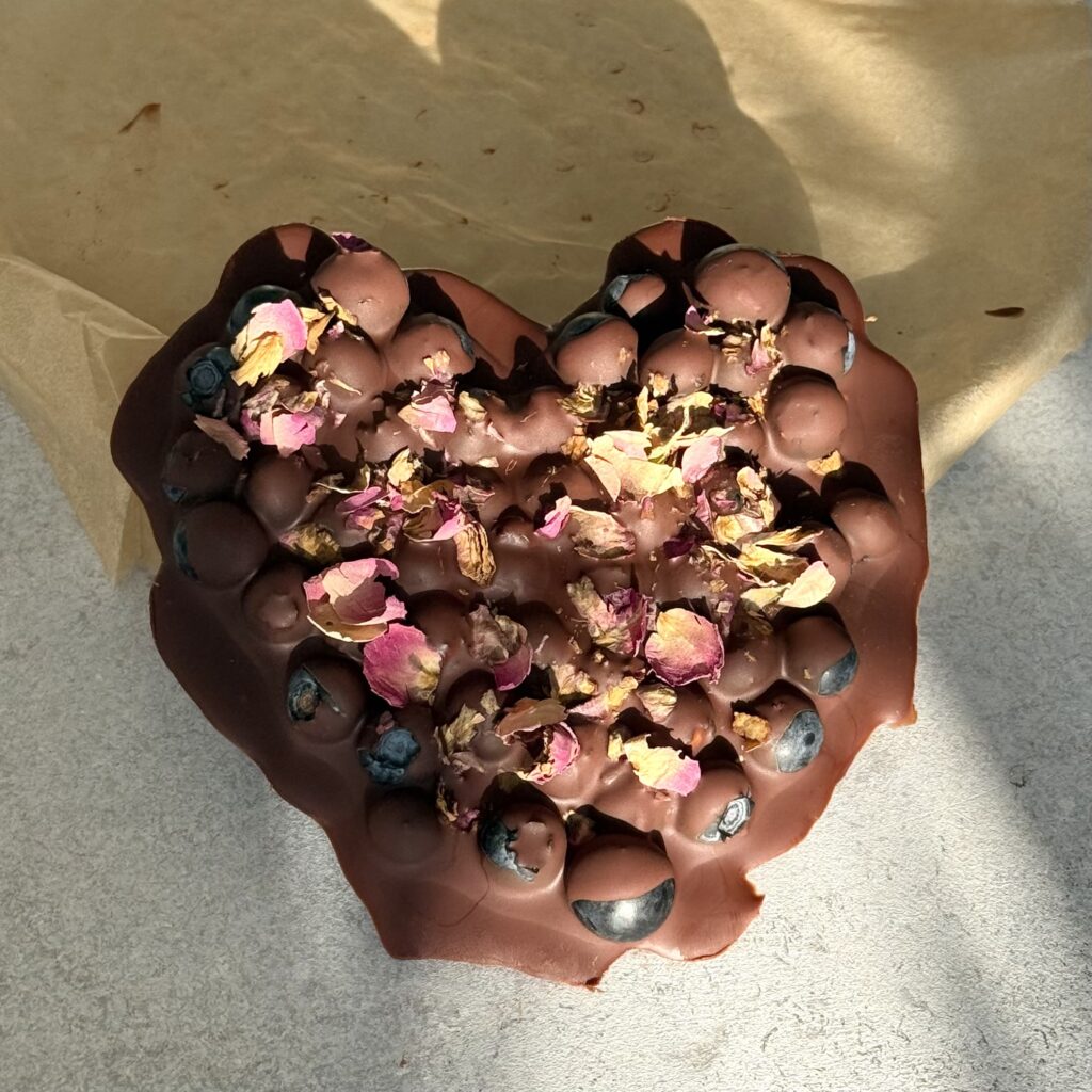 Blaubeer-Schoko-Herz angelehnt an deinem Teller.