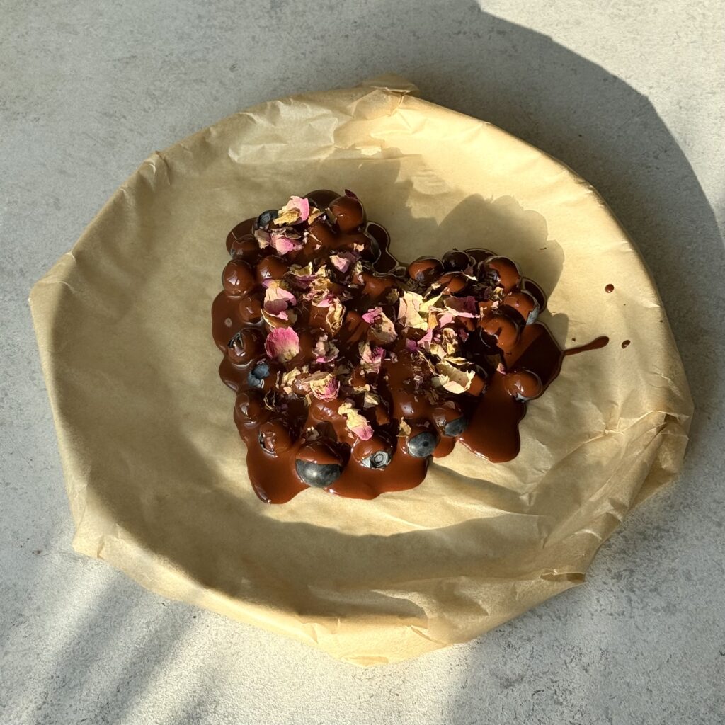 Blaubeer-Schoko-Herz liegt auf einem Teller.