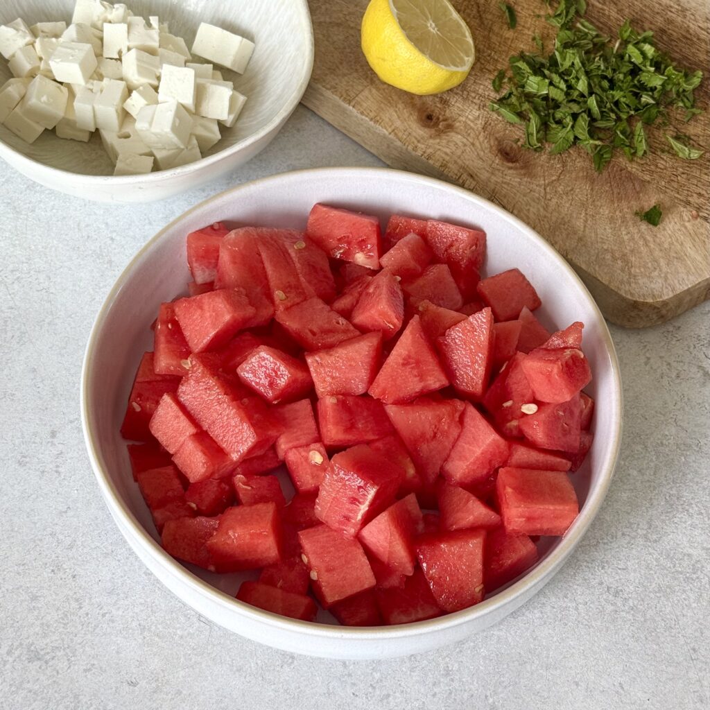Alle Zutaten für den Wassermelonen-Feta-Salat sind einzeln zu sehen.