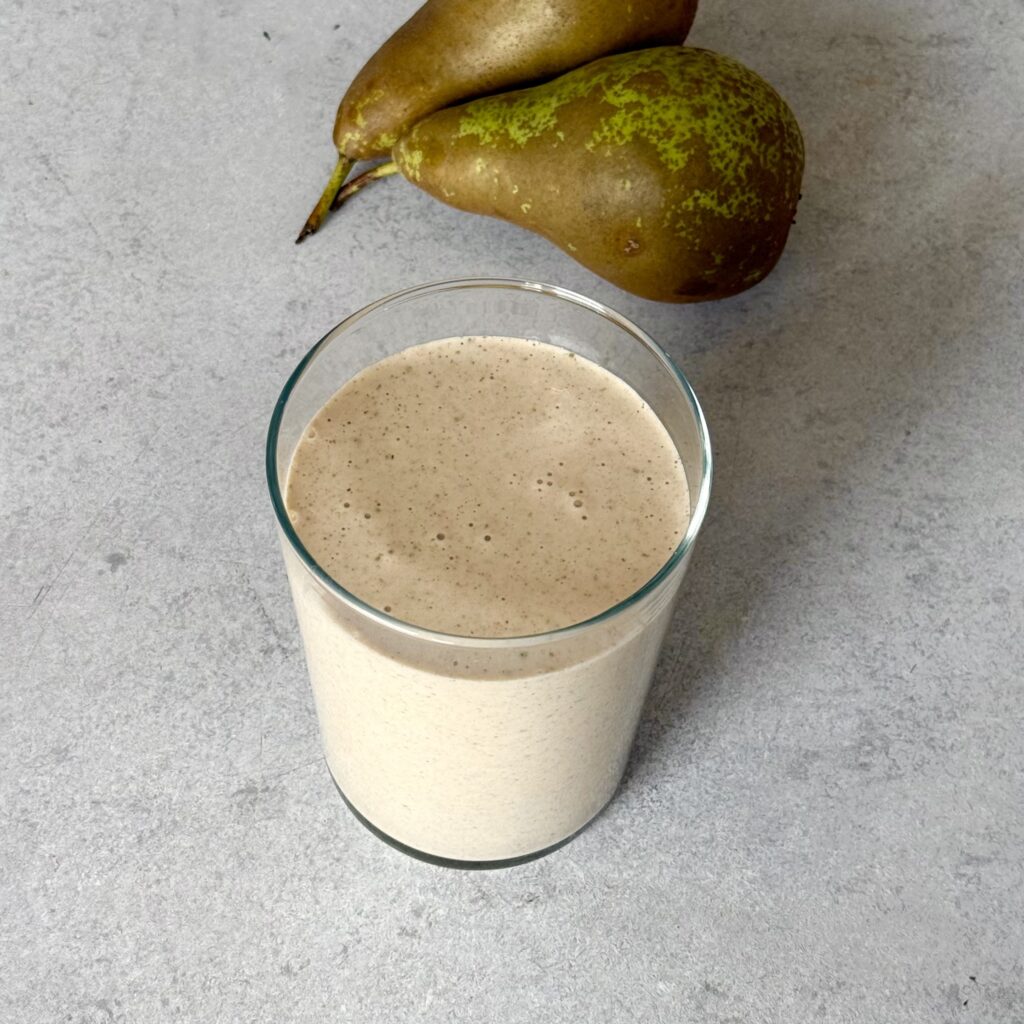 Birnen-Zimt-Protein-Smoothie (ohne Proteinpulver) mit zwei Birnen daneben.